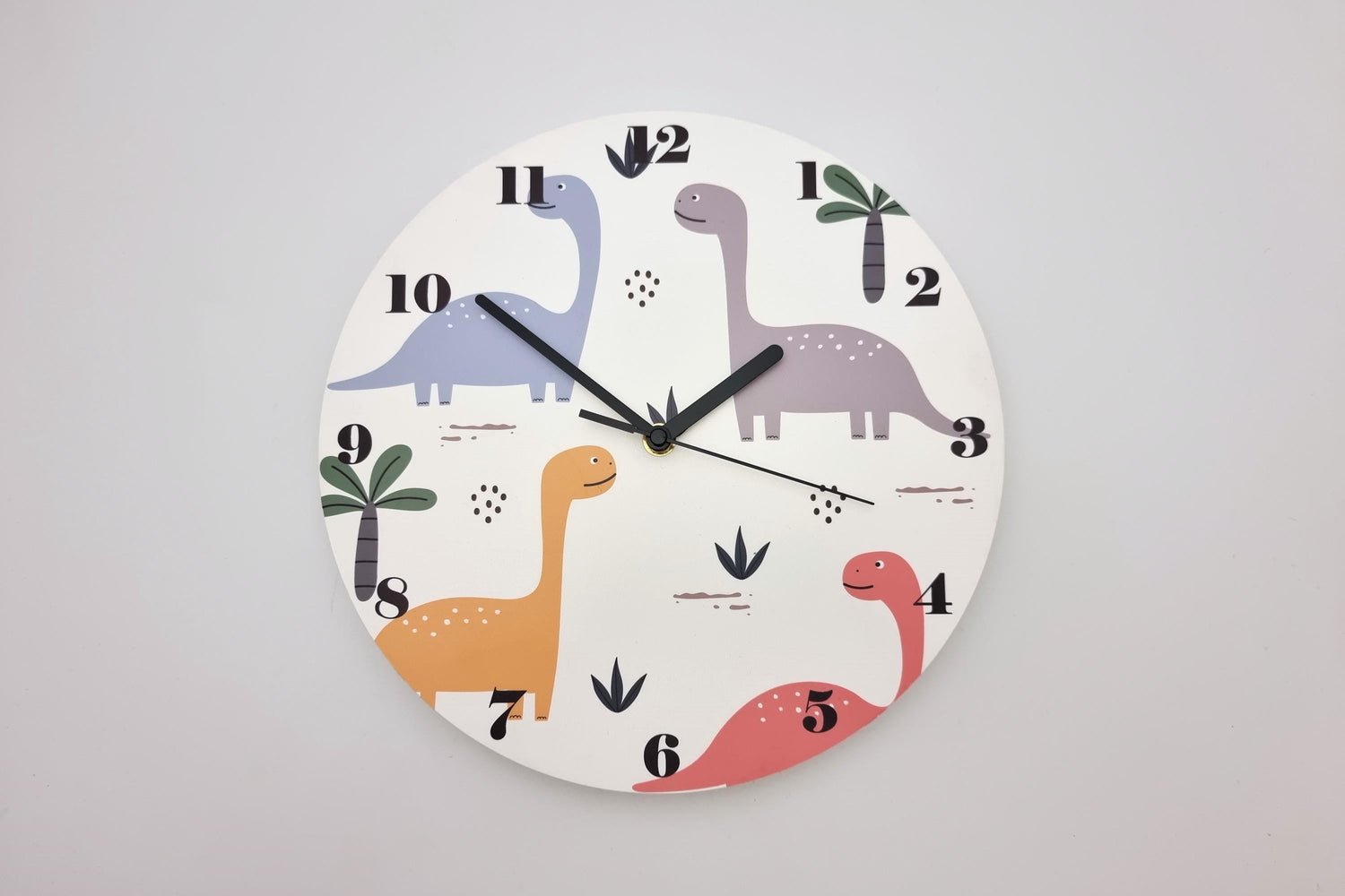 Round wall clock with colorful dinosaur illustrations, perfect for children's rooms or playful decor.