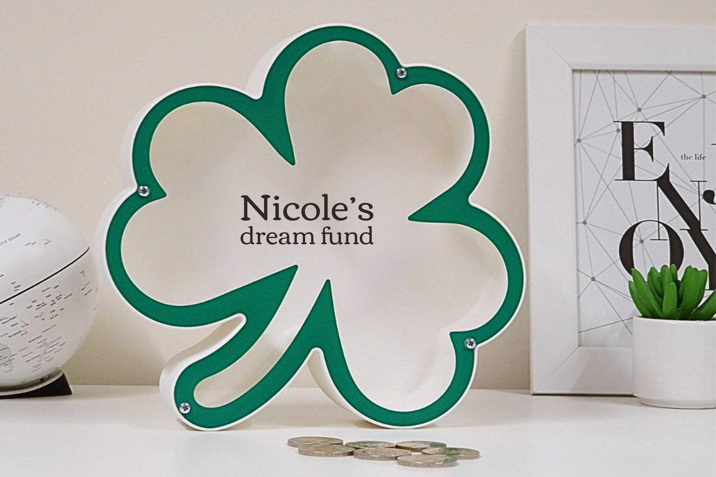 Green shamrock-shaped piggy bank personalized with 'Nicole's dream fund' text, perfect for St. Patrick's Day decor and saving.