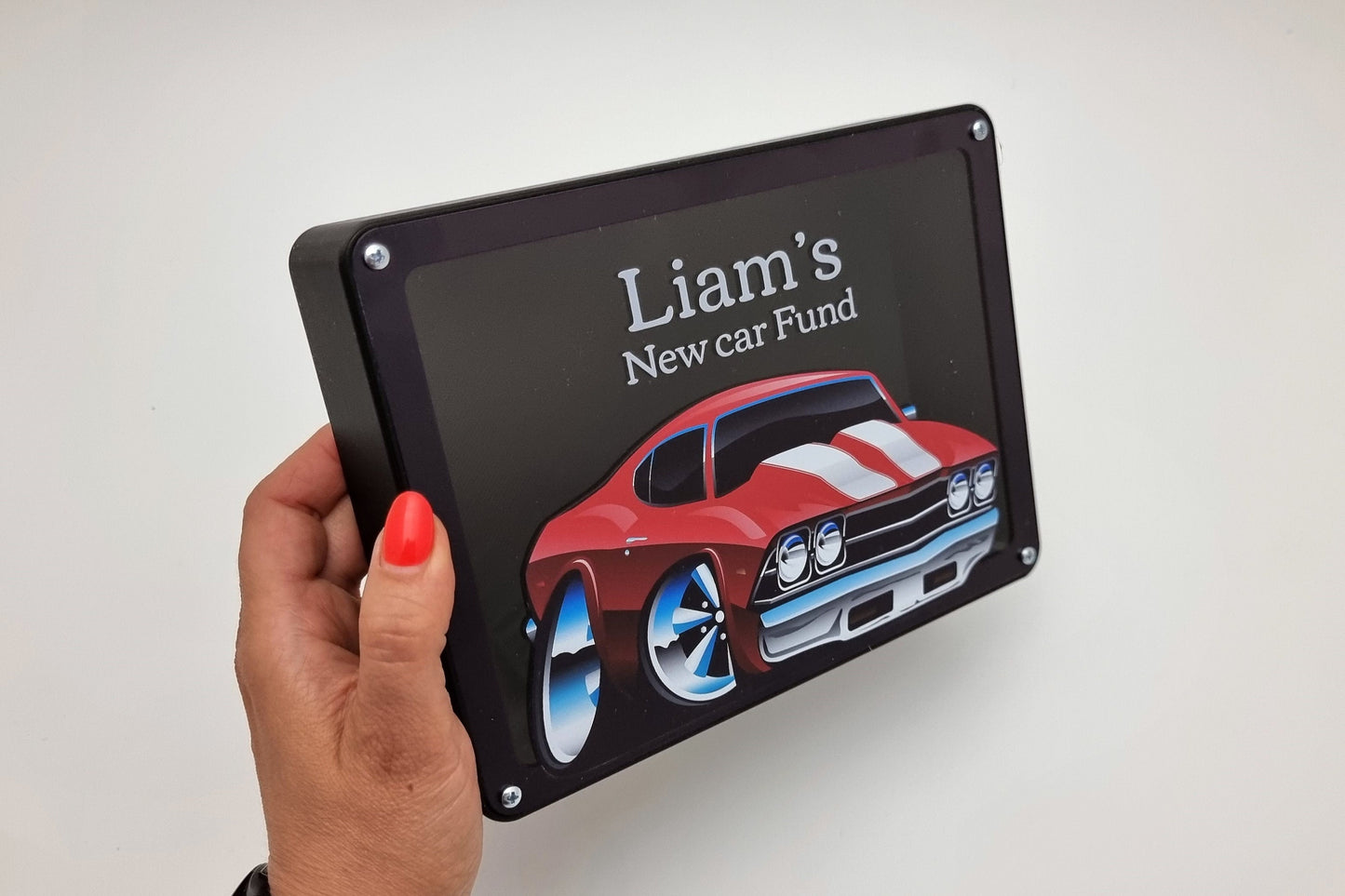 Personalized red car piggy bank held in hand, showcasing the sleek design.