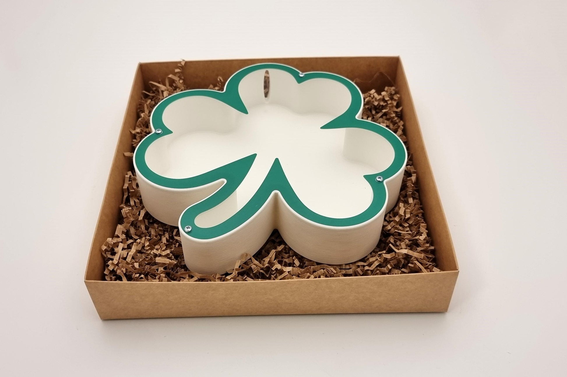 Shamrock-shaped piggy bank beautifully packaged in a gift box, ideal for St. Patrick's Day celebrations.